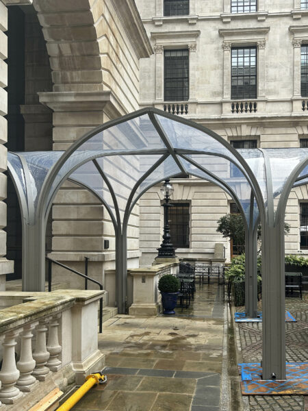 Image of steel canopy in front of stone building