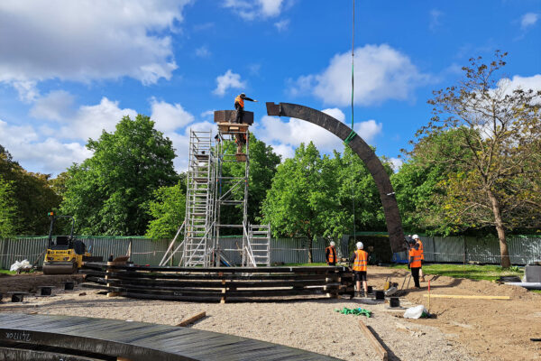 Photo of timber being lowered by crane during the build of a timber structure