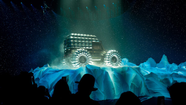 Photo of fashion car design on rotating stage surround by replica mountain setting