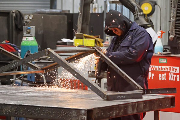 Photo of man grinding metal in metal workshop