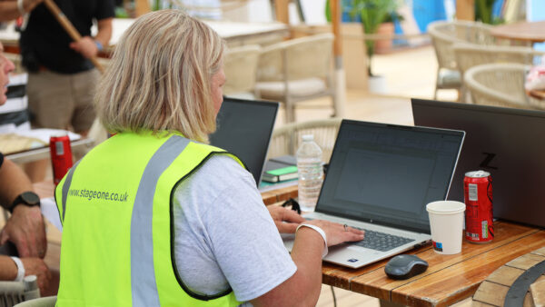 Woman working at a laptop wearing a high vis vest