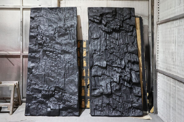 Photo of two rock-like GRP panels stood against a wall