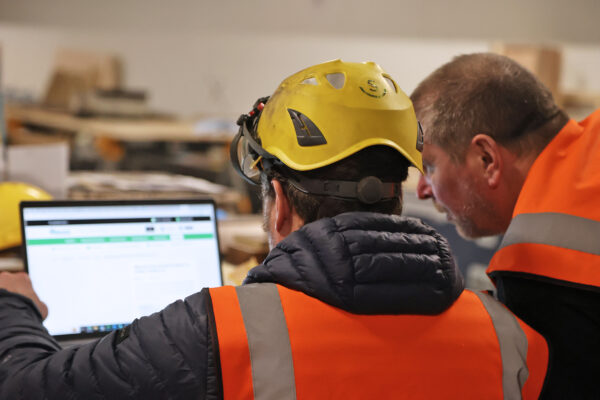 Crew members in discussion looking at a laptop screen