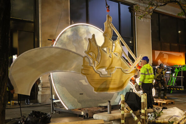 Photo of ship-design facia panel about to be lifted onto a store façade