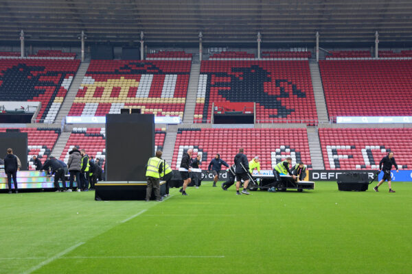 Image of teams removing structural items out of a football ground